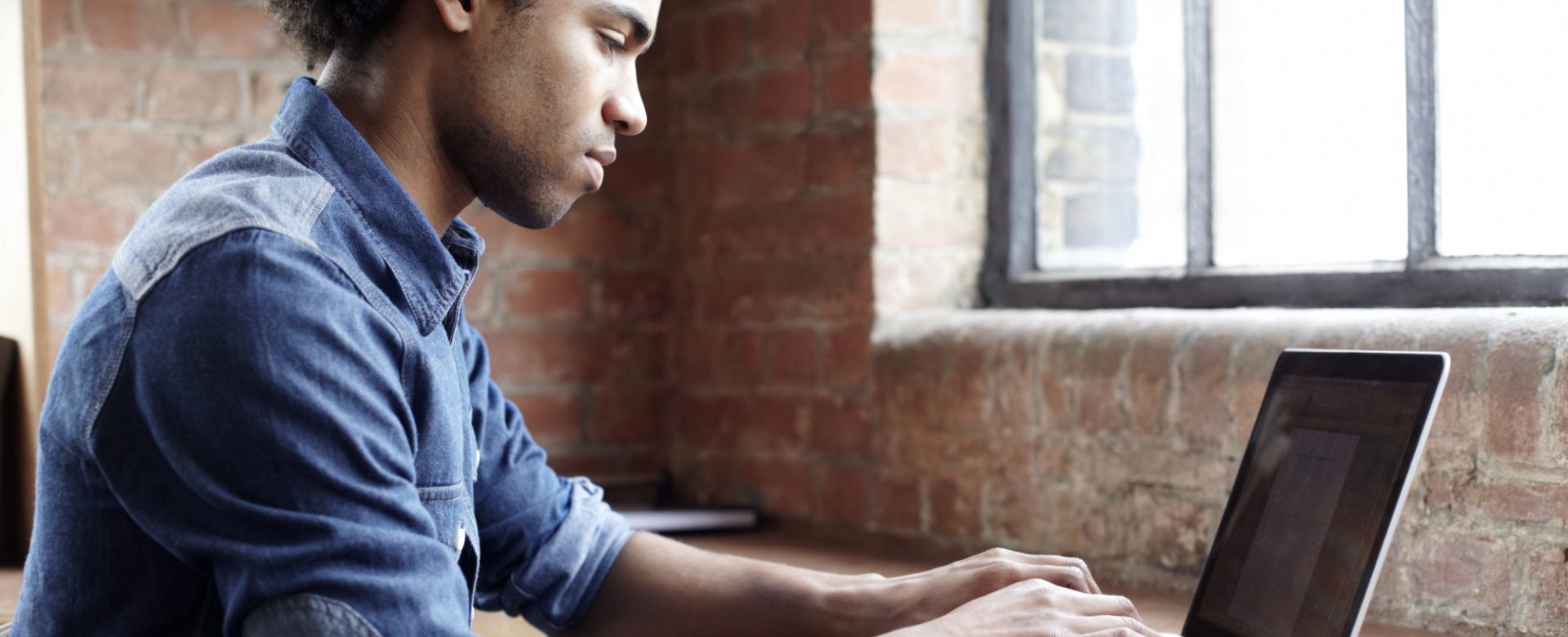 Young guy using laptop at desk